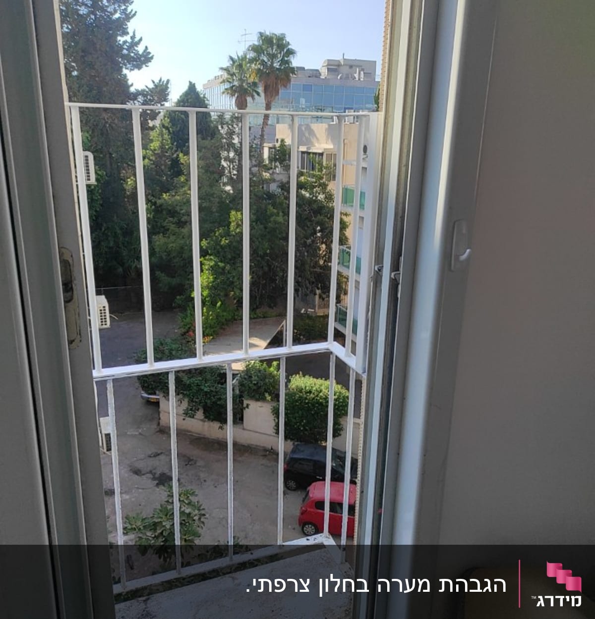 חלון פתוח עם סורגי מתכת לבנים